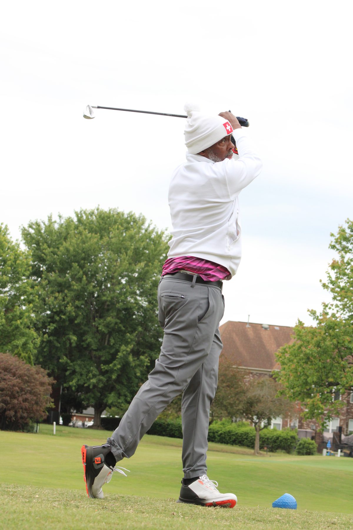 Golfer mid-swing at a charity outing